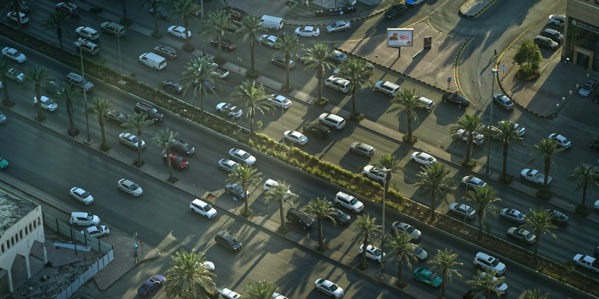 Vue aérienne d'une grande avenue plantée de palmiers et de sa circulation, Riyad